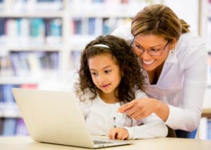 Enfant et professeur devant un ordinateur